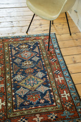 Geometric star motif border detail of a Karaja rug in madder red and indigo blue.