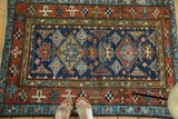Geometric red main border, indigo field, and sky blue patterns on a Karaja rug.