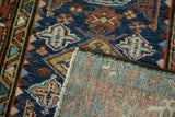 Karaja hand-knotted rug corner, showing geometric indigo, red pattern and woven back.