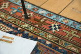 Geometric star motif border and stylized patterns in madder red and indigo on a Karaja rug.