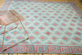 Vintage Dhurrie rug corner, red and celadon geometric diamond field and Greek key border.
