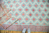 Hand woven Dhurrie carpet detail: geometric wave border, diamond pattern, celadon and red.