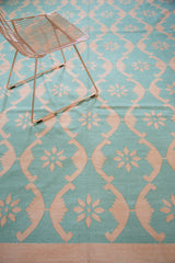 Aqua turquoise blue and blush rose floral ribbon lattice on hand woven Dhurrie carpet.