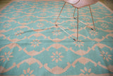 Aqua turquoise and blush rose floral lattice pattern on the hand-woven New Dhurrie carpet.