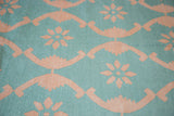 Hand woven Dhurrie carpet detail with floral ribbon lattice in aqua turquoise and blush rose.