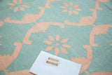 Hand woven Dhurrie carpet with aqua turquoise and blush rose floral lattice design.