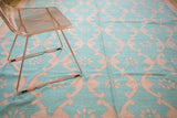 Hand woven Dhurrie rug with repeating aqua turquoise and deep blush rose floral lattice.