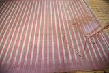 Crisp ivory and red striated lines on a vintage hand woven Dhurrie carpet.