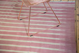 Hand-woven ivory and red Dhurrie rug with feathered striated lines and fringed edge.