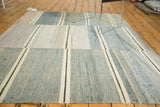 Modern hand woven rag rug, textured with asymmetrical ivory, denim blue, and dark stripes.