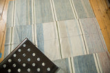 Textural surface of a vintage hand woven Turkish rag rug with asymmetrical blue and ivory stripes.