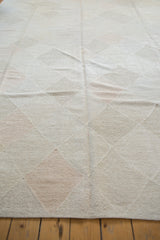 Geometric diamond lattice design on a pale stone and blush hand woven Kilim.