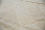 Hand woven kilim carpet texture detail with pale stone, slate grey, and blush lattice diamond design.