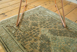 Distressed intricate pattern on vintage Sivas rug in sage green and peach.
