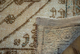 Distressed beige pile, hand-knotted foundation, and securely bound edge of the Kars runner.