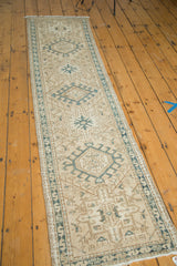 Evenly distressed vintage Karaja runner showing geometric medallion and moss green serpent border.