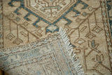 Corner of Karaja runner revealing geometric pattern, hand-knotted foundation, distressed pile, and ivory fringe.
