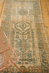 Angled view of a vintage Karaja runner's geometric patterns in muted beige and blue-green.
