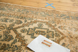 Hand-knotted vintage Karaja rug detail showing geometric patterns in beige, brown, and muted blue.