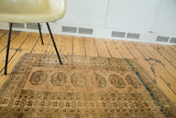 Vintage Afghan rug's linear elephant footprint medallions with pale copper and bronze abrash.