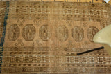 Afghan rug with linear elephant footprint medallions, floral border, and copper abrash.