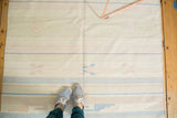 Southwestern vintage Dhurrie rug with feet, showing pale geometric patterns and light staining.