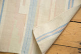 Corner of vintage Dhurrie rug revealing tightly woven flatweave and Southwestern stripes.