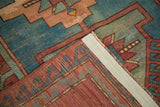 Hand-knotted back and geometric pattern of a vintage Caucasian rug's folded corner.