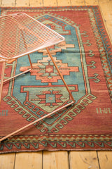 Vintage Caucasian rug outer border, brick red field, wave motif, and 1941 inscription.