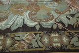 Earthen green and brown rococo-like rose and leaf motifs with geometric border detail.