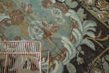 Stylized rose and leaf motifs on a muted green and brown Turkish Kilim.