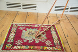 Intricate naturalistic center and floral border of vintage Oushak rug in cherry red.