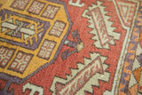 Vintage Oushak rug geometric pattern in saffron yellow, faded red, and mauve.