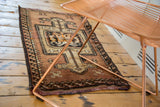 Oushak runner's tattered bottom end and irregular bronze, sand, charcoal barber pole border.