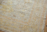 Distressed antique Kaisary rug texture with muted light gold and pale orange patterns.