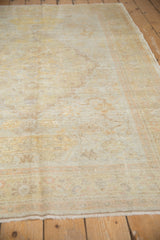 Secured fringed end of antique Kaisary rug, showing faded gold and pale orange border.