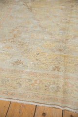 Soft, distressed pile of the antique Kaisary rug with faded gold and pale orange floral motifs.