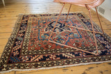 Vintage Heriz rug corner with bold geometric main border and floral motifs.