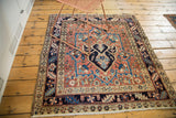 Heriz rug lower corner showcasing ivory fringe, bold geometric main border, and brick red.