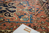 Vintage Heriz rug detail: brick red, navy, and aqua traditional geometric and floral patterns.