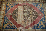 Distressed vintage Oushak carpet with intricate oversized medallion and rich abrash colors.