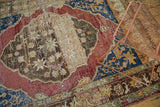 Distressed indigo blue and black cherry red Oushak rug corner with floral abrash patterns.