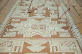 Geometric Turkish runner with ivory and bronze quintuplet star medallions, angled view.