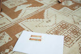 Hand-knotted vintage Oushak rug detail showing ivory and bronze geometric pattern.