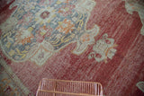 Richly textured crimson red distressed Oushak with faded ivory and saffron medallion detail.
