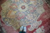 Distressed vintage Oushak carpet with cloudband pennants in crimson, saffron, and ivory.