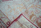 Hand knotted backing and distressed pile of a vintage Oushak rug in red and beige.