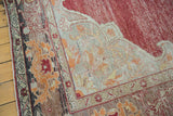 Distressed crimson red pile and beige cloudband motif on vintage Oushak rug.