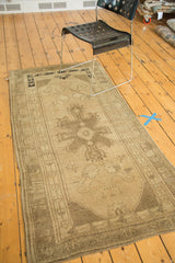 Vintage Oushak runner's central medallion with natural wooded and charcoal floral designs.