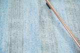 Symmetrical striped pattern in pale sky blue and pale charcoal hues.